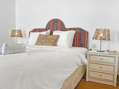 a white bed with two lamps on a night stand at 180° SEAVIEW Apt. right on famous beach promenade in Larnaka