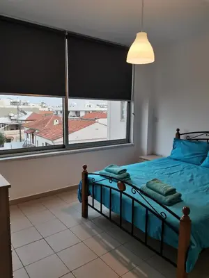 a bedroom with a bed and a large window at City Flats 308 in Larnaka