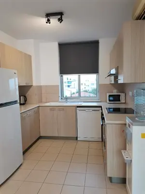 a kitchen with a white refrigerator and a window at City Flats 308 in Larnaka