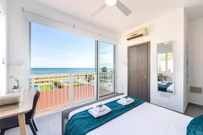 a bedroom with a bed and a view of the ocean at Ayia Thekla Seafront Villa Dagi in Ayia Napa