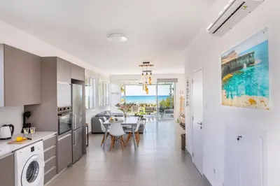 a kitchen and dining room with a table and chairs at Ayia Thekla Seafront Villa Dagi in Ayia Napa