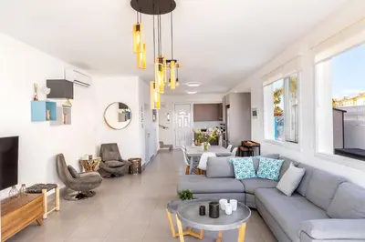 a living room with a couch and a table at Ayia Thekla Seafront Villa Dagi in Ayia Napa