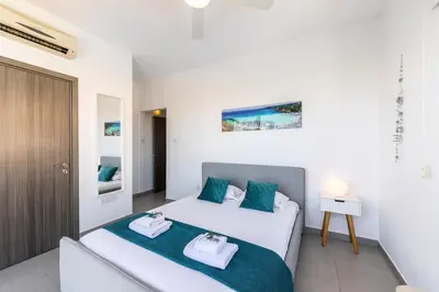 a bedroom with a bed with two towels on it at Ayia Thekla Seafront Villa Dagi in Ayia Napa