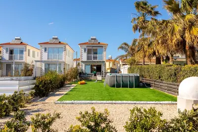 a house with a lawn in front of it at Ayia Thekla Seafront Villa Dagi in Ayia Napa