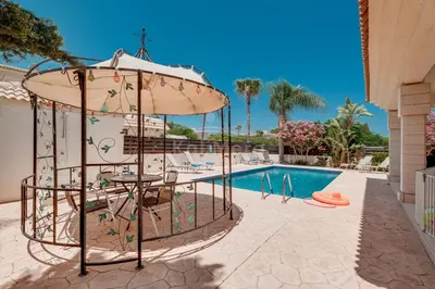 a pool with a table and an umbrella next to a swimming pool at Villa Hanna in Protaras