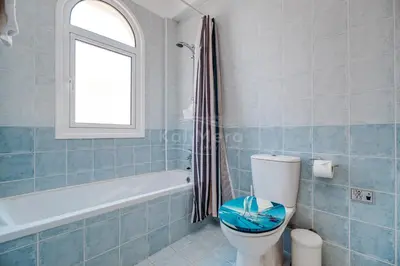 a bathroom with a toilet and a tub and a window at Villa Hanna in Protaras