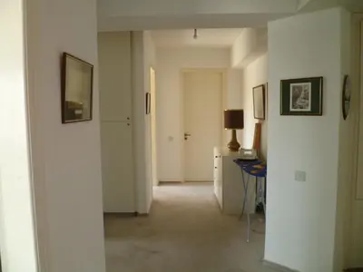 a hallway with a room with white walls and a desk at Datacom House - The Sky Blue Room in Nicosia