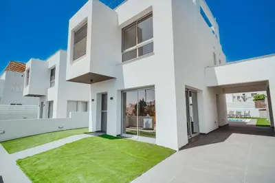 a white house with a green lawn at Stay in Style in Modern 3 Bedroom Villas Near Nissi Beach & Square in Ayia Napa