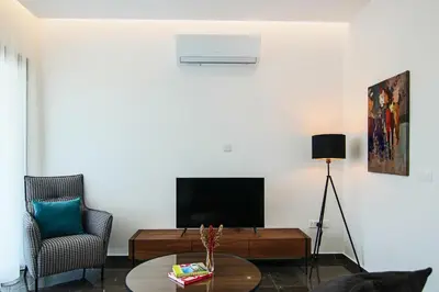 a living room with a tv and a table at Phaedrus Living: City View Anna Residence 101 in Limassol