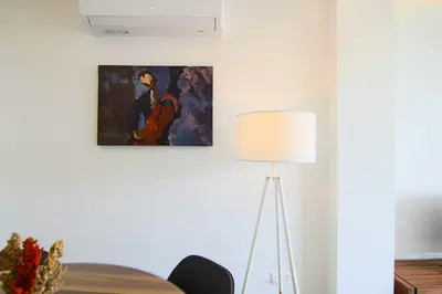 a table with a lamp and a painting on the wall at Phaedrus Living: City View Anna Residence 102 in Limassol