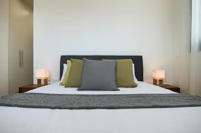 a bed with two lamps on either side of it at Phaedrus Living: City View Anna Residence 102 in Limassol