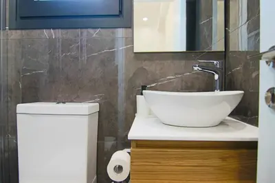 a bathroom with a sink and a toilet and a mirror at Phaedrus Living: City View Anna Residence 102 in Limassol