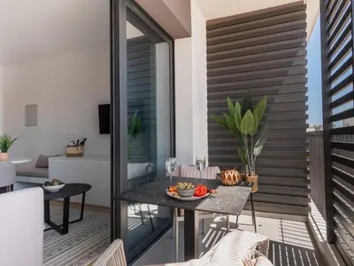 a patio with a table and chairs on a balcony at Armonta Residences by BeCyprus in Limassol