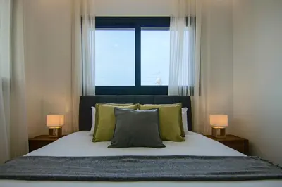a bedroom with a bed with a window and two lamps at Phaedrus Living: Sea View Anna Residence 201 in Limassol