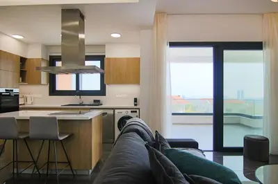 a living room with a couch and a kitchen at Phaedrus Living: Sea View Anna Residence 201 in Limassol