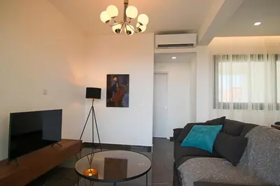 a living room with a couch and a flat screen tv at Phaedrus Living: Sea View Anna Residence 202 in Limassol