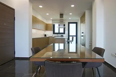 a kitchen and dining room with a wooden table and chairs at Phaedrus Living: Sea View Anna Residence 302 in Limassol