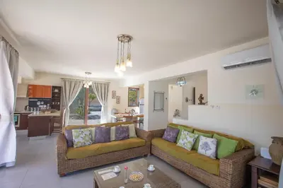 a living room with two couches and a kitchen at Villa Margarita in Protaras