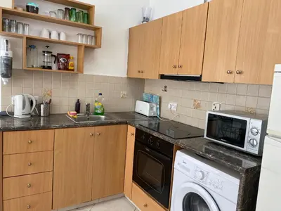 a kitchen with a washing machine and a sink at 1 bedroom flat 200m from the beach in germasogia tourist area in Limassol