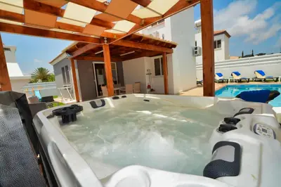 a jacuzzi tub in the backyard of a house at Nissi Villa Sotia in Ayia Napa