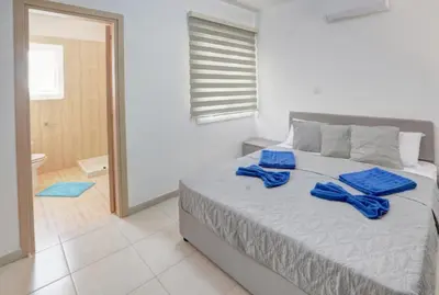 a bedroom with a bed with blue towels on it at Nissi Villa Sotia in Ayia Napa