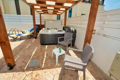 a patio with a grill and chairs and a table at Nissi Villa Sotia in Ayia Napa
