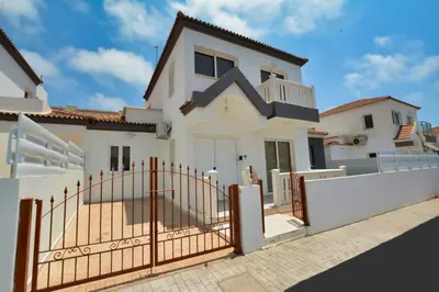 a white house with a gate and a fence at Nissi Villa Sotia in Ayia Napa