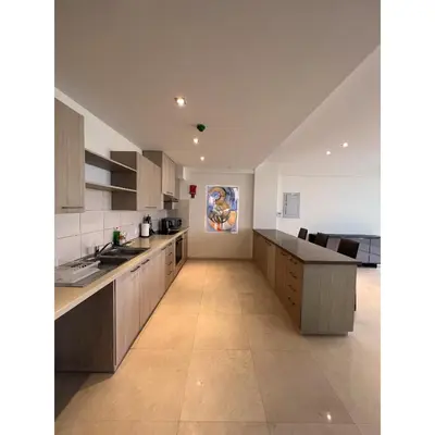 a large kitchen with white cabinets and a large painting on the wall at Aphrodite Plaza in Larnaka