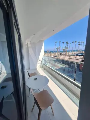 a balcony with a table and chairs and a view of the beach at Aphrodite Plaza in Larnaka