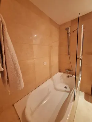 a white bath tub in a bathroom with a shower at Aphrodite Plaza in Larnaka