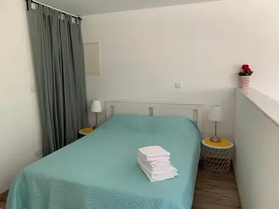 a bedroom with a bed with a blue blanket and two lamps at STUDIO in CAPTAINS HOUSE WITH A POOL in Limassol