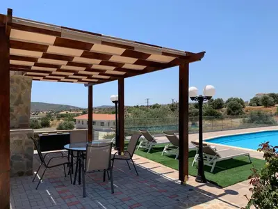 a patio with a table and chairs and a pool at STUDIO in CAPTAINS HOUSE WITH A POOL in Limassol