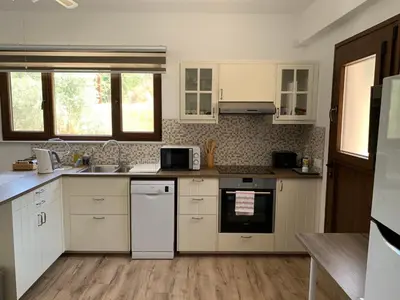 a kitchen with white appliances and wooden floors at STUDIO in CAPTAINS HOUSE WITH A POOL in Limassol