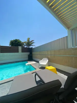 a swimming pool with a table and chairs next to it at Purple Villa Protaras - Paralimni in Paralimni