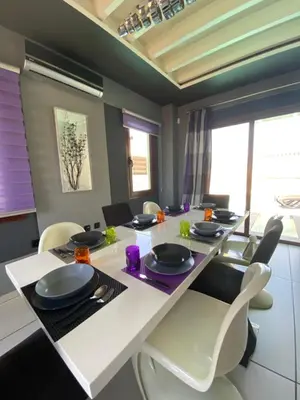 a dining room with a white table and chairs at Purple Villa Protaras - Paralimni in Paralimni