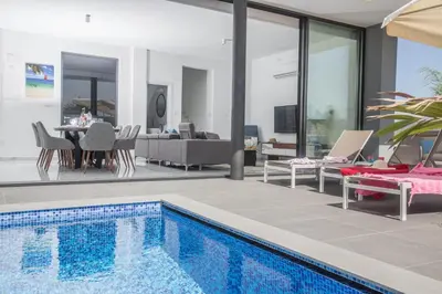 a house with a swimming pool and a dining room at Anassa Seaview Villa - Stunning Panoramic Views in Protaras