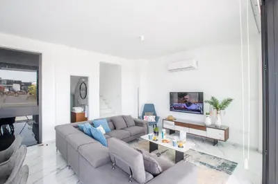 a living room with a couch and a tv at Anassa Seaview Villa - Stunning Panoramic Views in Protaras