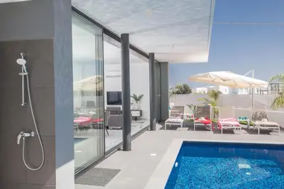 a bathroom with a swimming pool and a house at Anassa Seaview Villa - Stunning Panoramic Views in Protaras