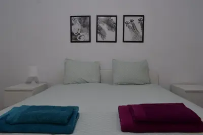 a bedroom with a bed with three pictures on the wall at MAMA'S FLAT - ΤΟ ΔΙΑΜΕΡΙΣΜΑ ΤΗΣ ΜΑΜΑΣ in Strovolos