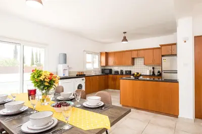 a kitchen with a table with plates and glasses on it at Voroklini Villa with Pool in Larnaka