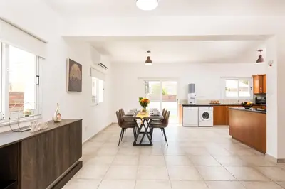 a kitchen and dining room with a table and chairs at Voroklini Villa with Pool in Larnaka