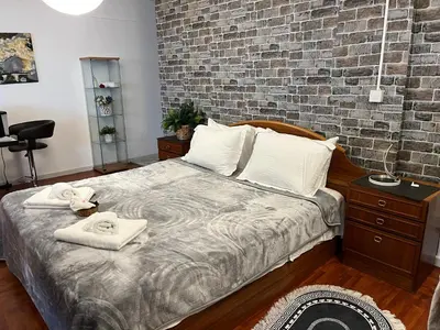 a bedroom with a bed and a brick wall at Lovely Cozy Apartment in the entrance of Nicosia in Aglantzia