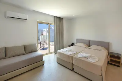 a bedroom with a bed and a couch at Panas Villas in Ayia Napa