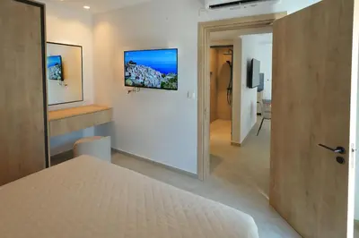 a bedroom with a white bed and a mirror at Panas Villas in Ayia Napa