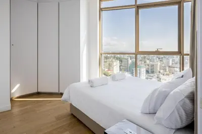 a bedroom with a white bed and a large window at 360 Nicosia - Luxury Apartment Panoramic View in Nicosia