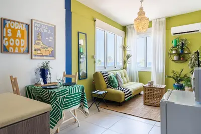 a living room with yellow and green walls at Whispering Palms 1-BR Apt By Finikoudes Beach in Larnaka