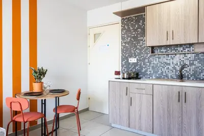 a kitchen with a table and chairs and a sink at Made with love 1-BR Apt By Finikoudes Beach in Larnaka