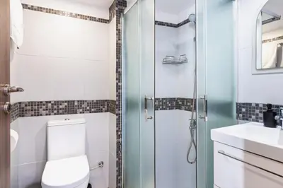 a bathroom with a toilet and a shower at Made with love 1-BR Apt By Finikoudes Beach in Larnaka