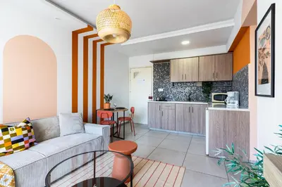 a living room with a couch and a kitchen at Made with love 1-BR Apt By Finikoudes Beach in Larnaka