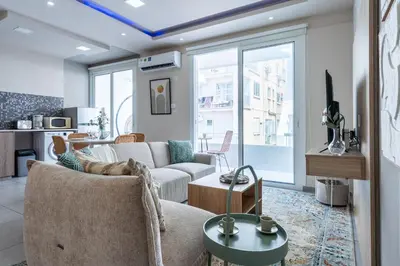 a living room with a couch and a table at Beach Daze 1-BR Apt By Finikoudes Beach in Larnaka